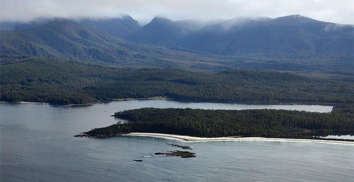 An aerial view of a lake surrounded by mountains and trees.