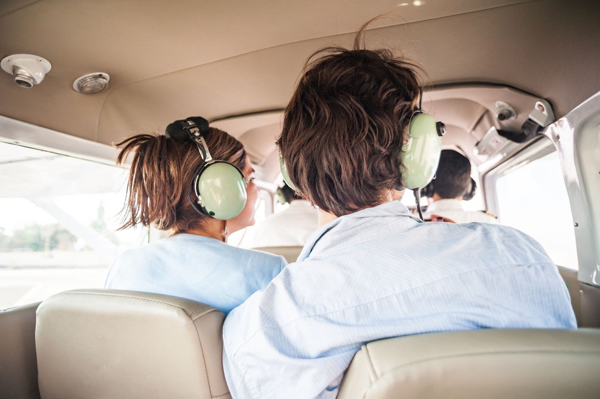 A young couple enjoying aerial views during a scenic flight adventure tour. A young couple enjoying aerial views during a scenic flight adventure tour.
