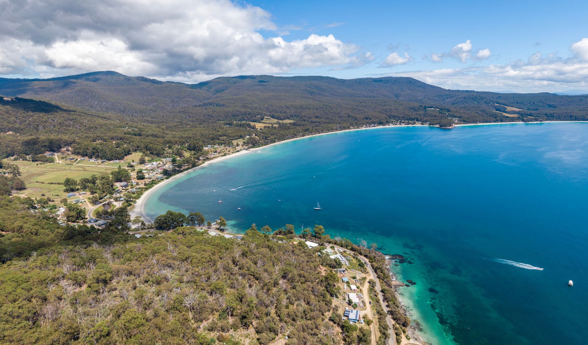 An aerial view of a long beach next to a body of water.