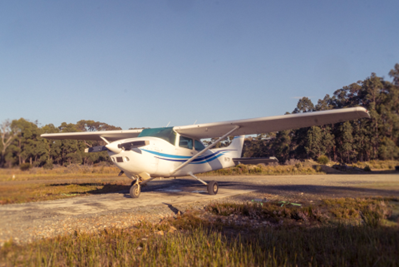 Cessna 182 airplane on the Ground with a clear blue sky.