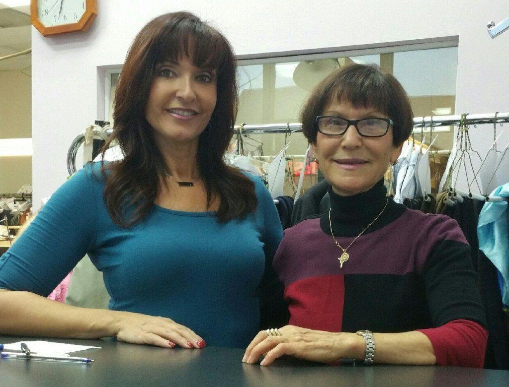 Two women are posing for a picture in front of a clock
