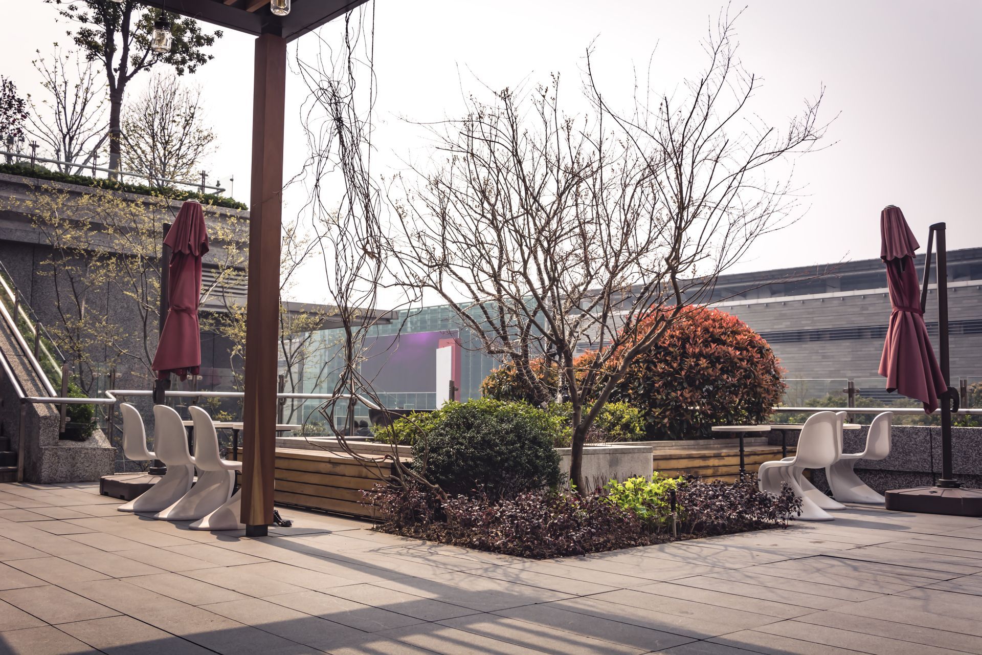 A patio with tables and chairs and umbrellas on a sunny day.