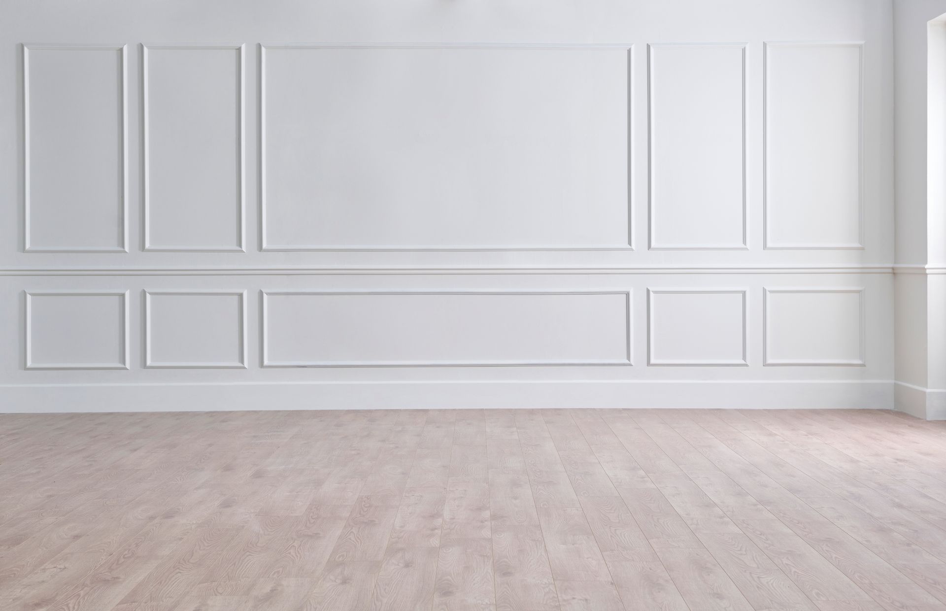 An empty room with white walls and a wooden floor.