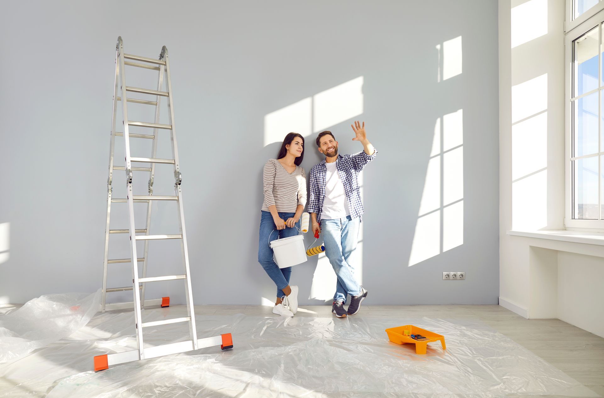 A man and a woman are standing next to each other in an empty room.