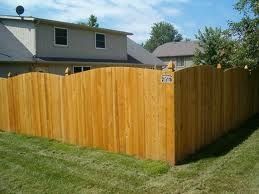 A wooden fence is in the backyard of a house.