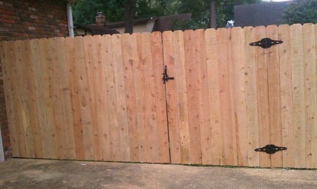 A wooden fence with a gate attached to it.