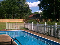 A large swimming pool with a white fence around it