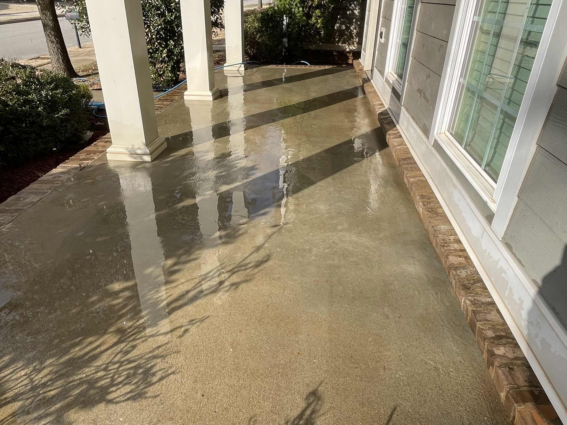 A flooded porch of a house with a lot of water on it
