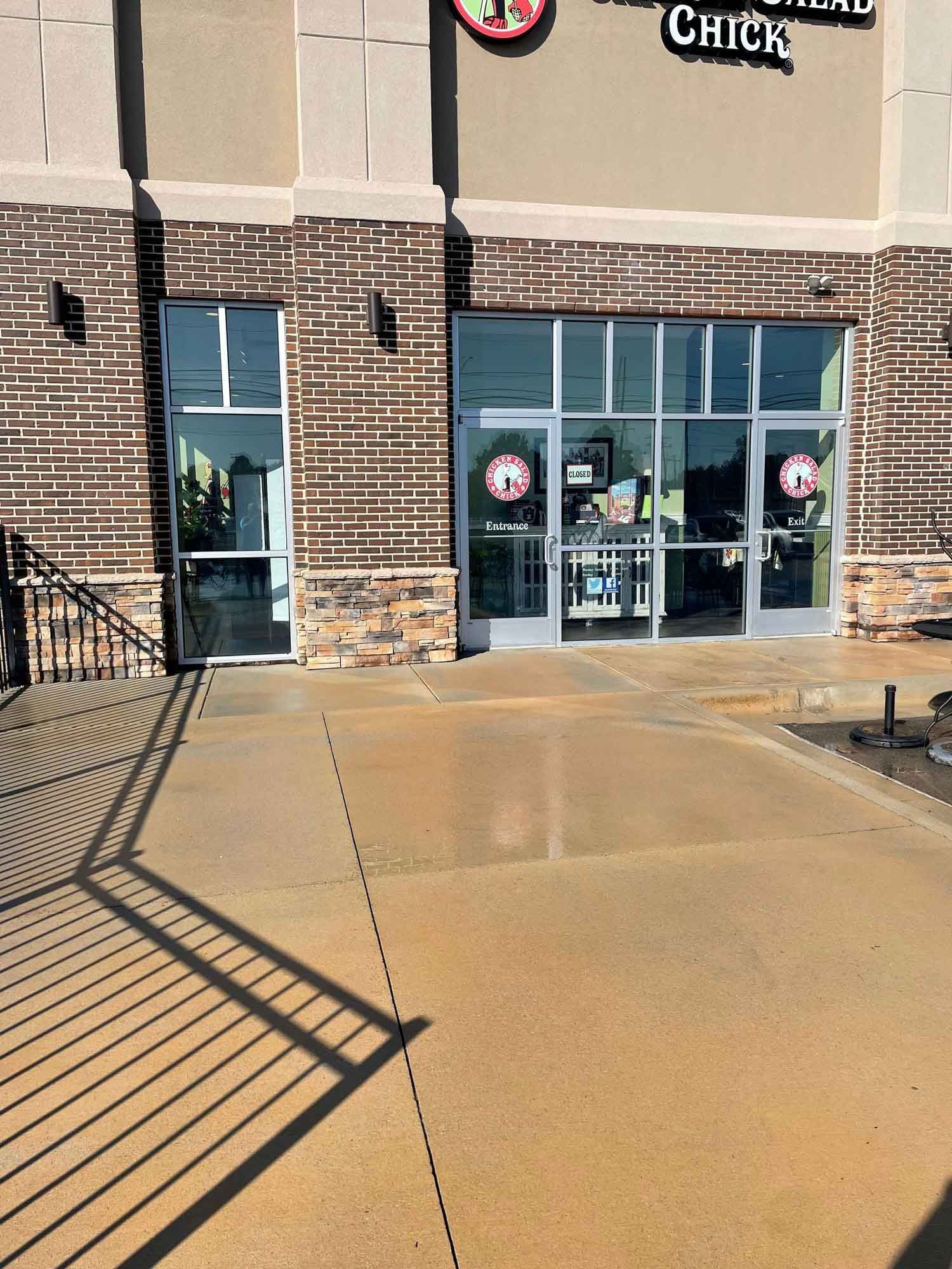 A man is using a high pressure washer to clean a floor