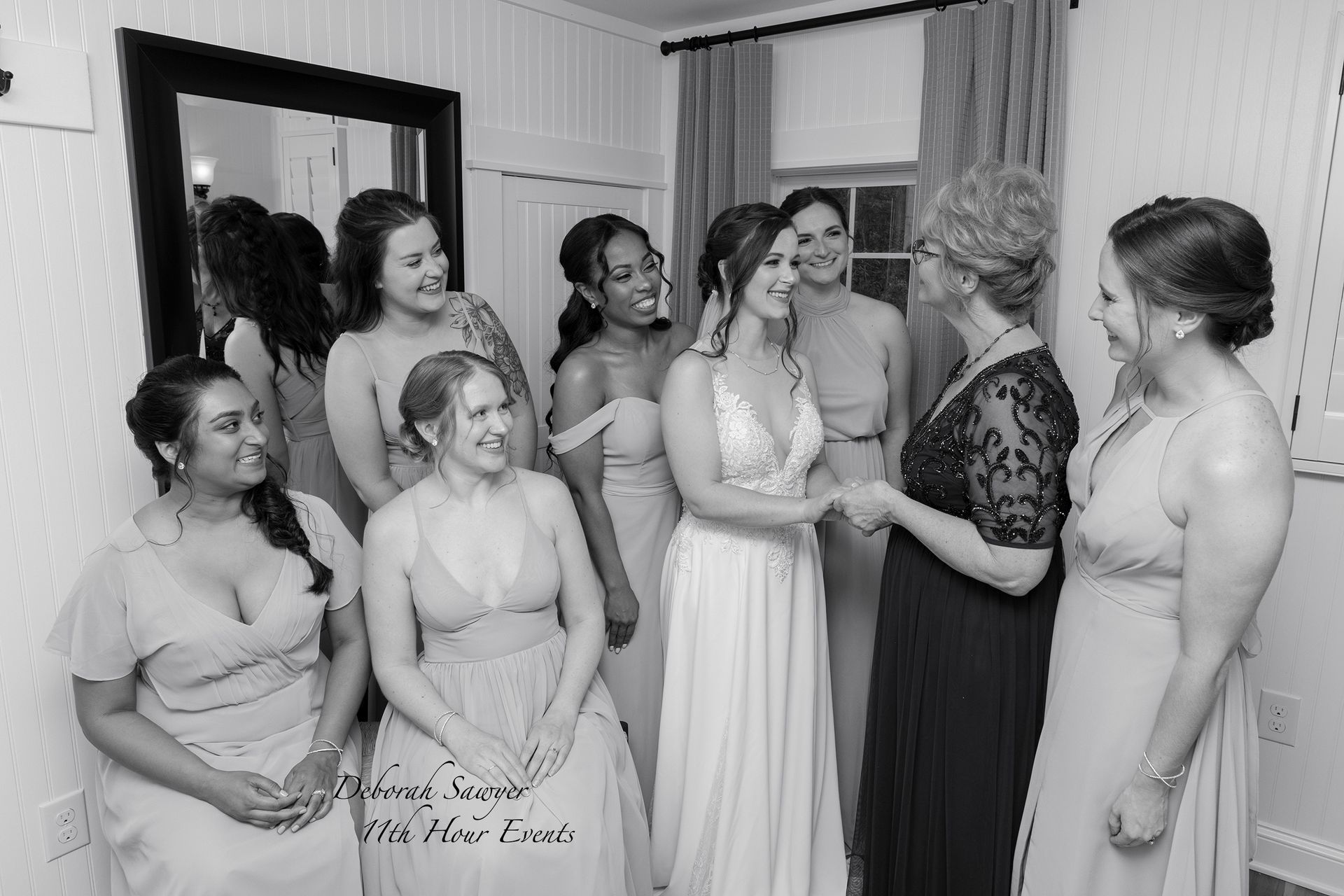 Bridesmaids and the bride in a room, congratulating each other before the wedding. Black and white photo.