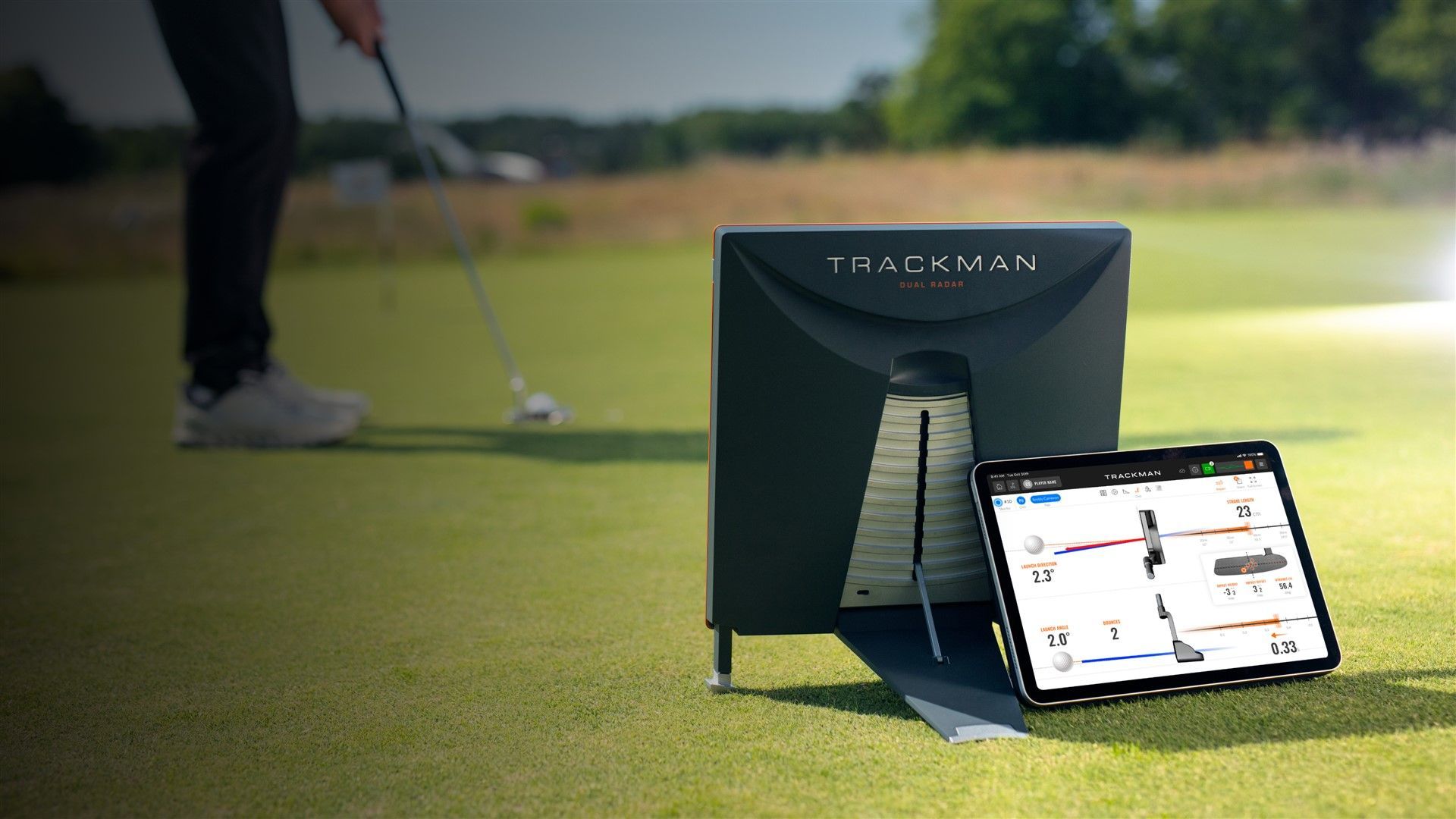Golfer using a golf putting training device on a green; a tablet displays data.