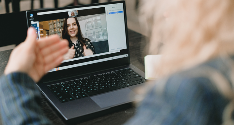 A woman is having a video call on a laptop computer.