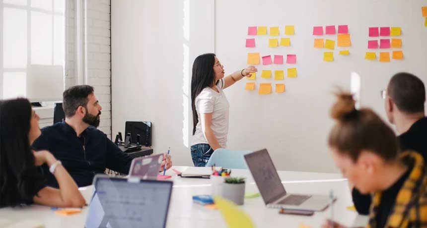 A woman is giving a presentation to a group of people in a conference room.