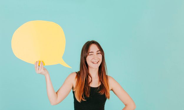 A woman is holding a yellow speech bubble over her head.