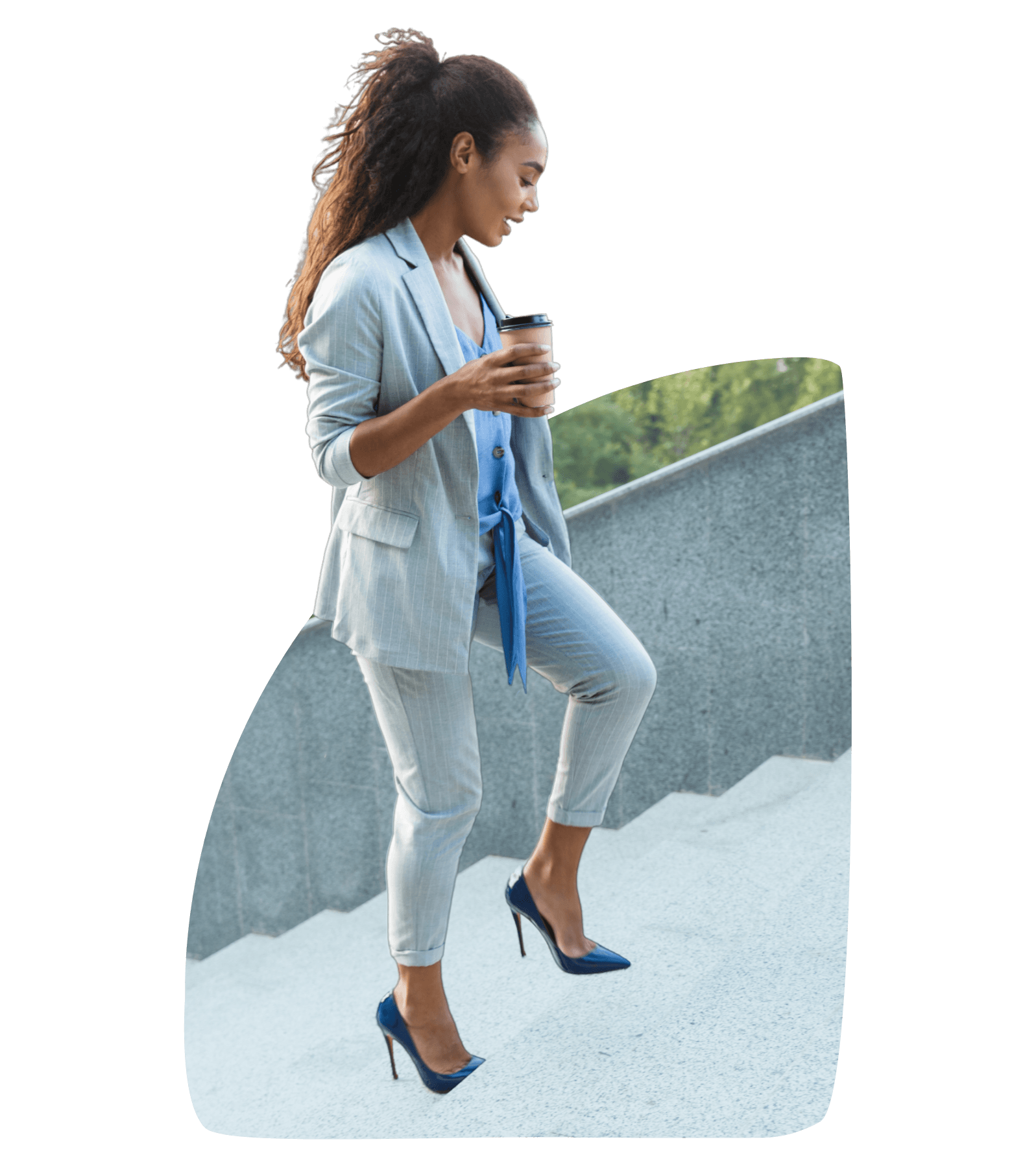 A woman is walking up a set of stairs while holding a cup of coffee.