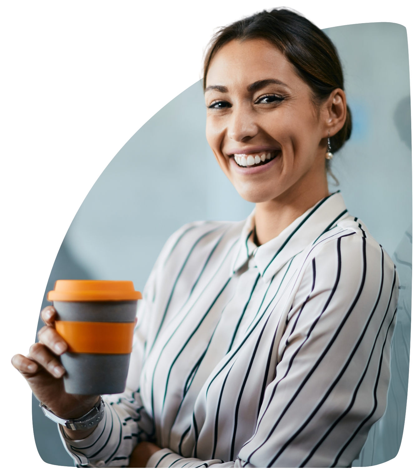 A woman in a striped shirt is holding a cup of coffee and smiling.