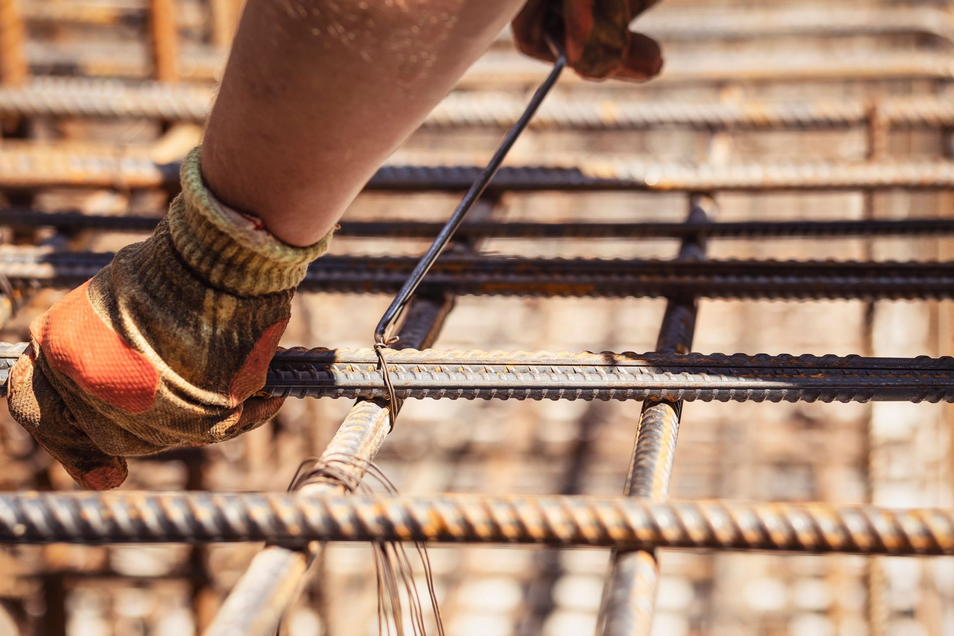 Builder tying rebar reinforcing steel bars of reinforced concrete base foundation. Builder tying rebar reinforcing steel bars of reinforced concrete base foundation.