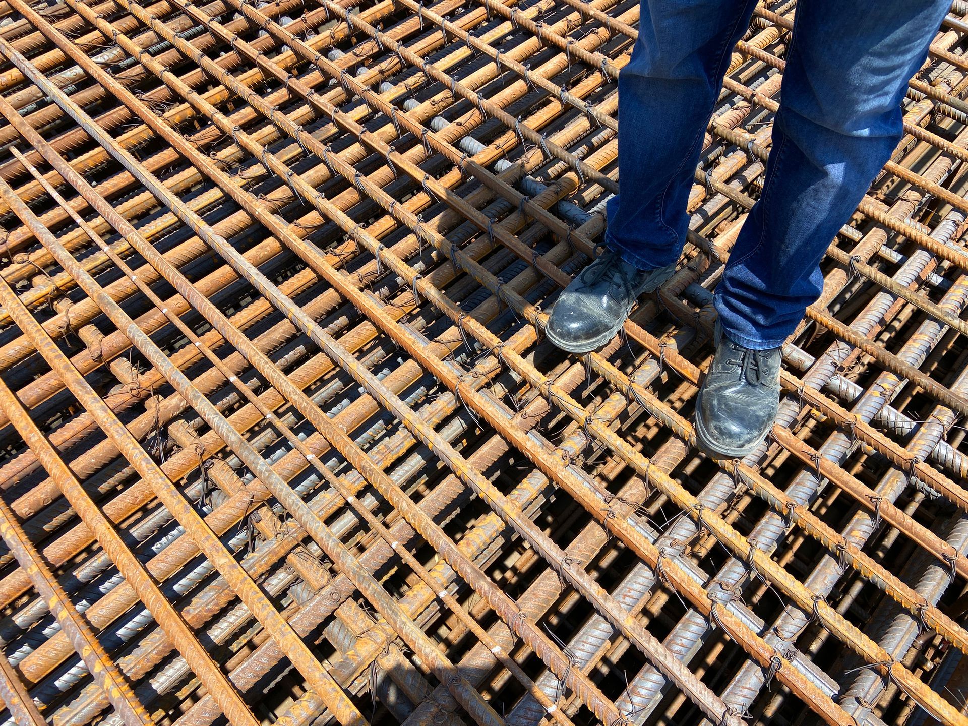 Close up of an Engineer’s feet on steel reinforcement mesh.
