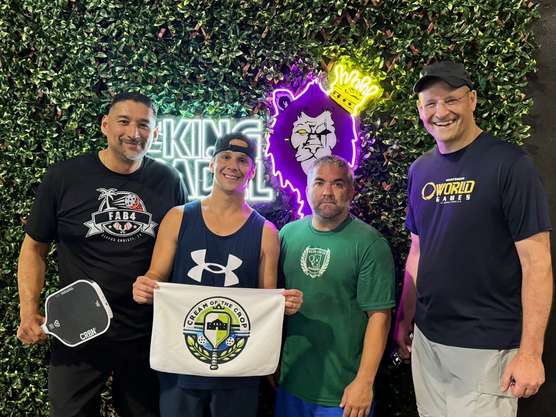 A man and a woman are cutting a cake in front of a sign that says padel club
