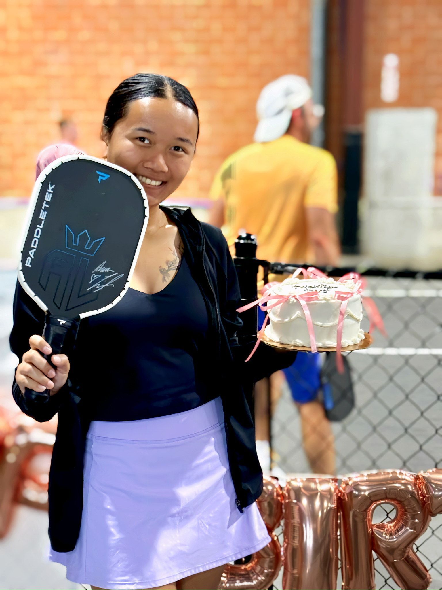A woman is playing a game of paddle tennis on a court.