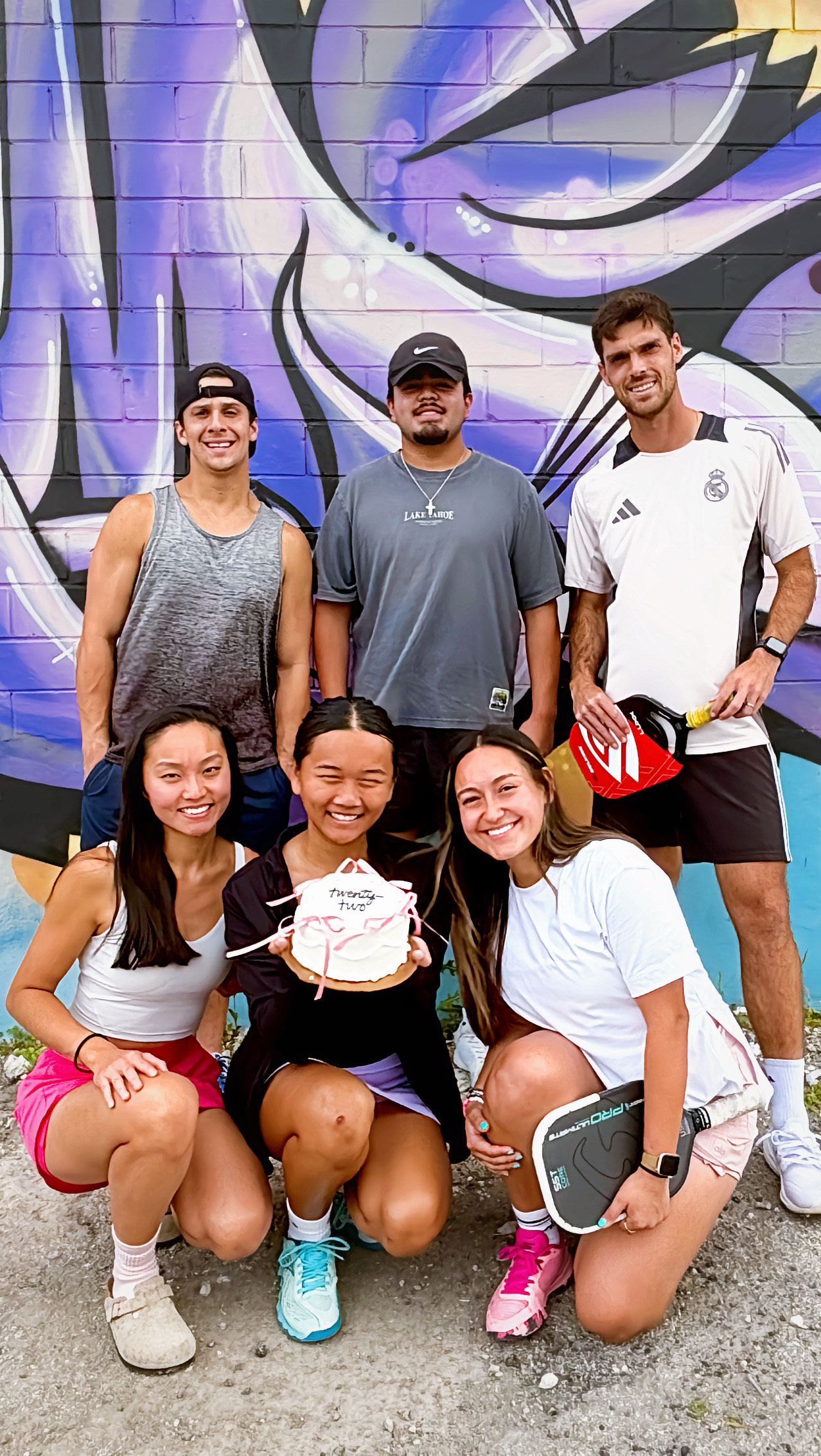 Two men are playing paddle tennis on a court.