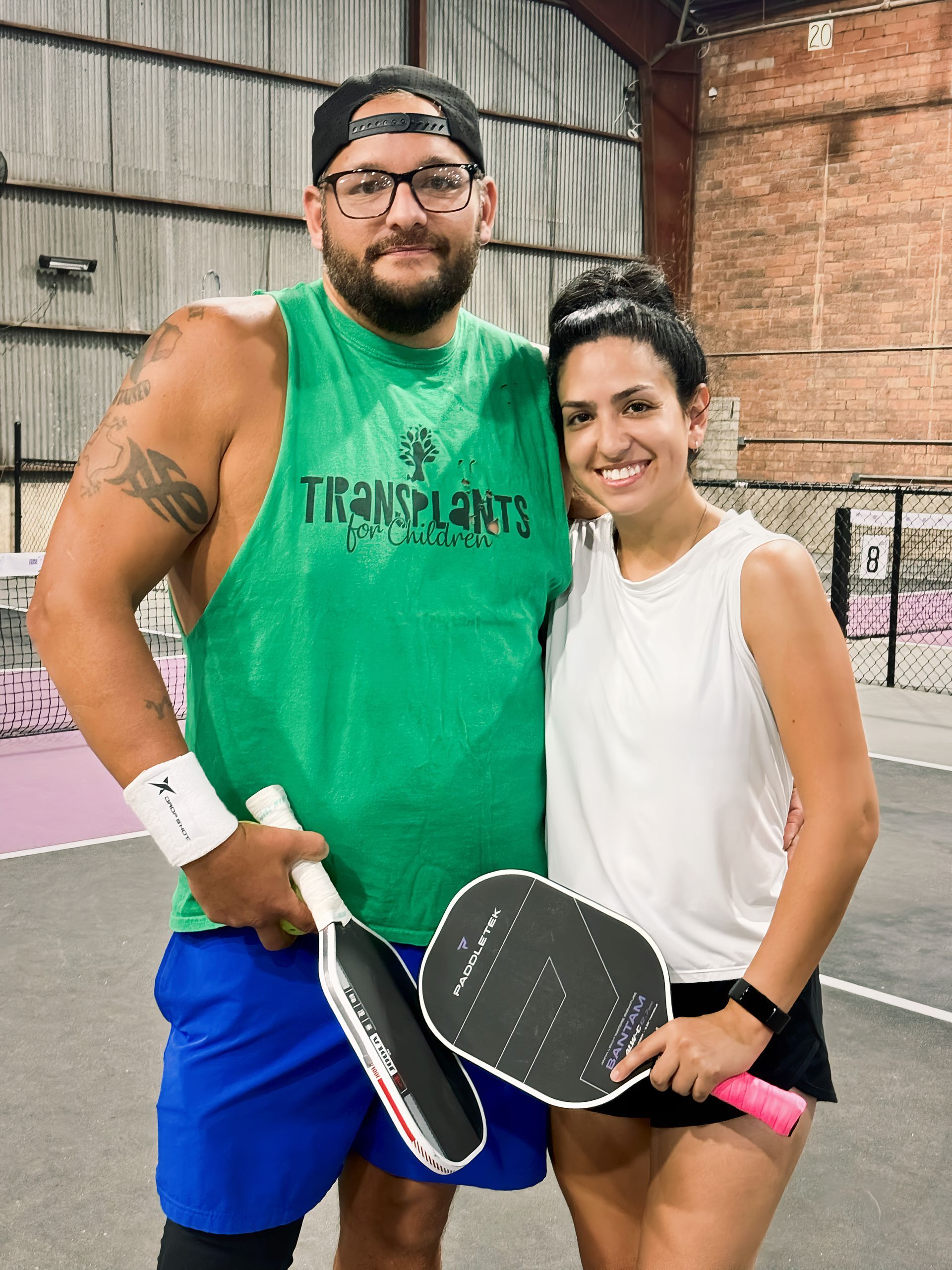 A woman is holding a paddle in front of a king paddles sign.