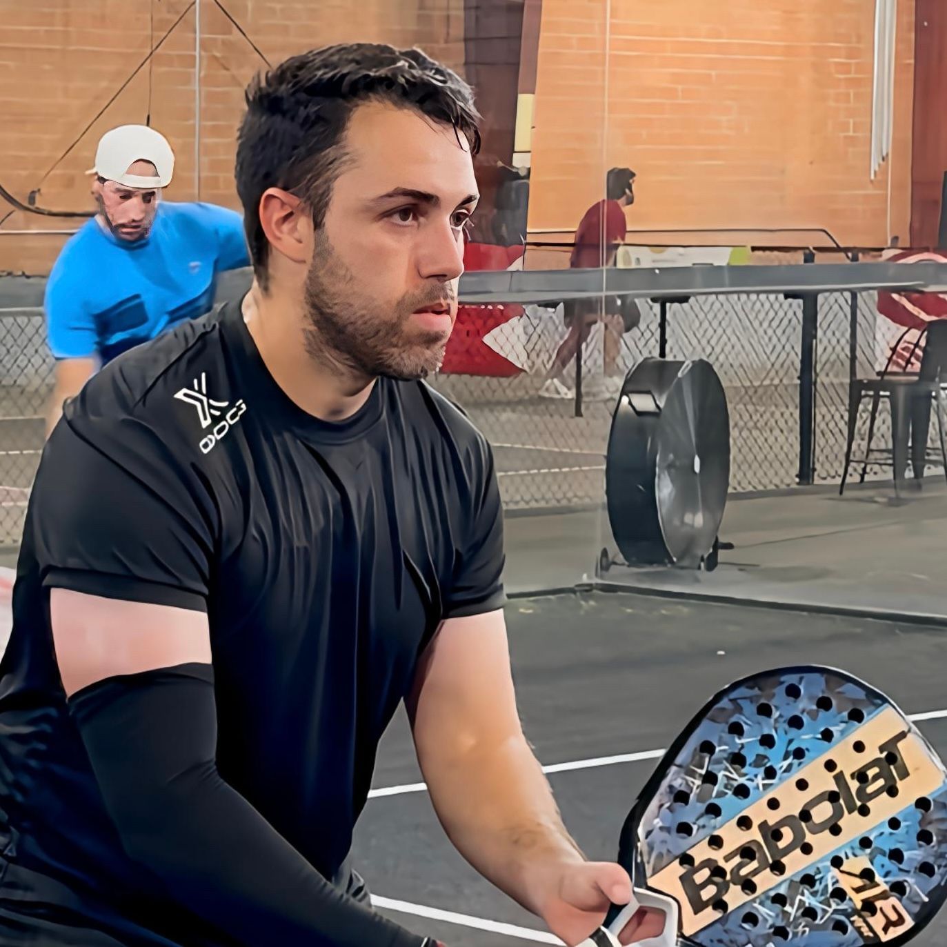 A woman is playing paddle tennis on a court.
