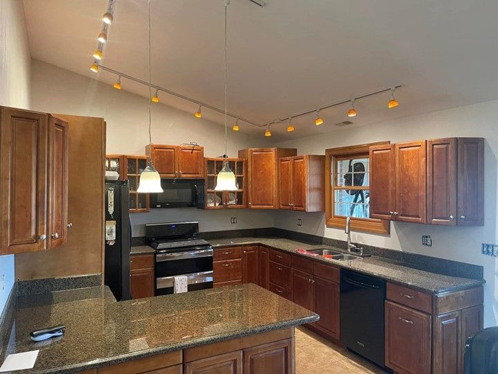 A kitchen with wooden cabinets and granite counter tops.