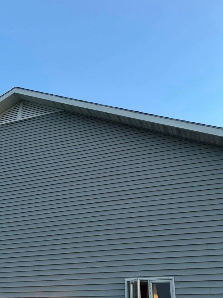 A gray house with a blue sky in the background