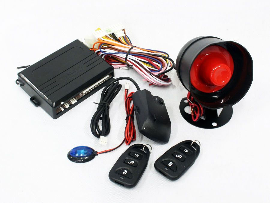 A car alarm with a red speaker and two remotes