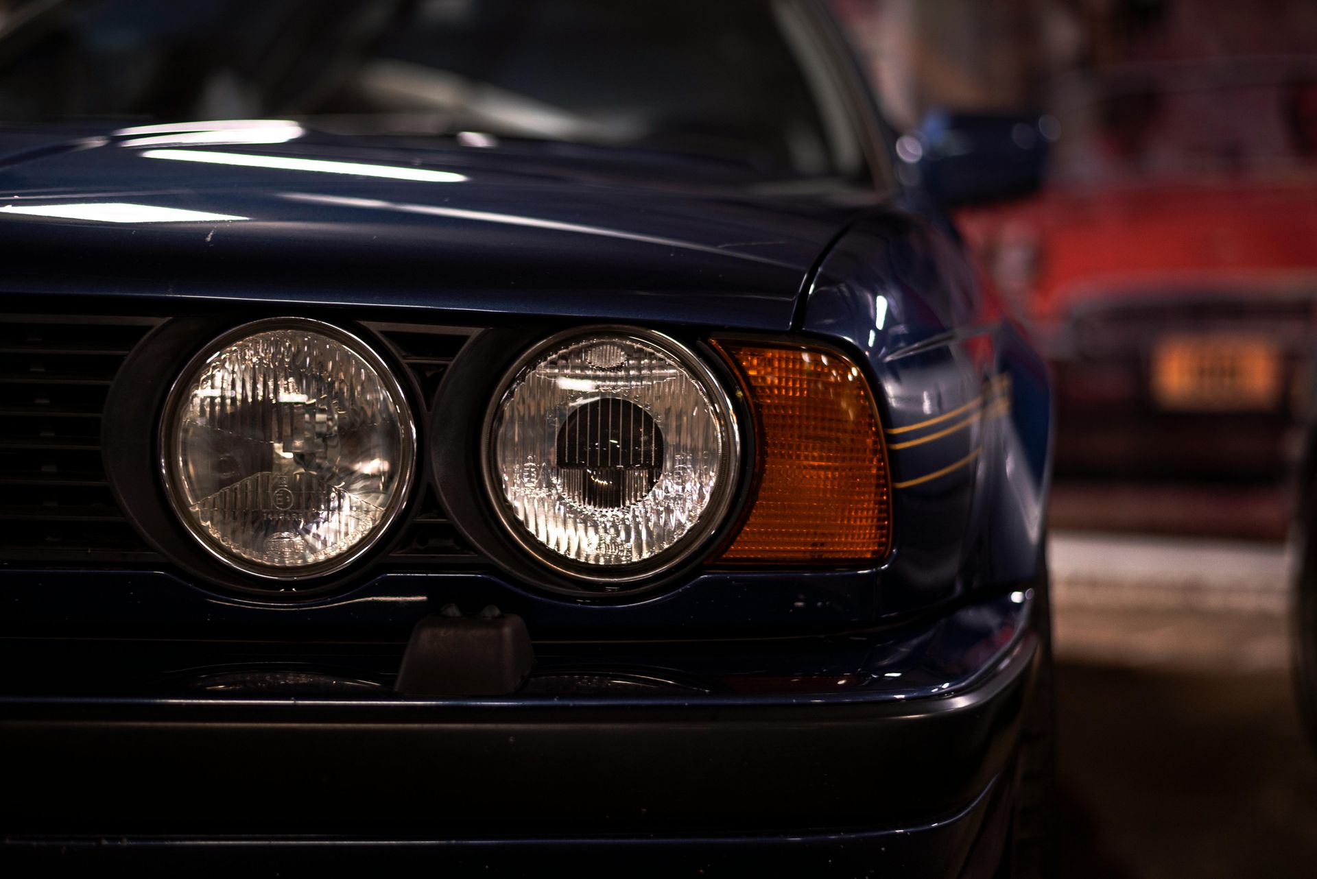 A close up of a car 's headlights in a garage.