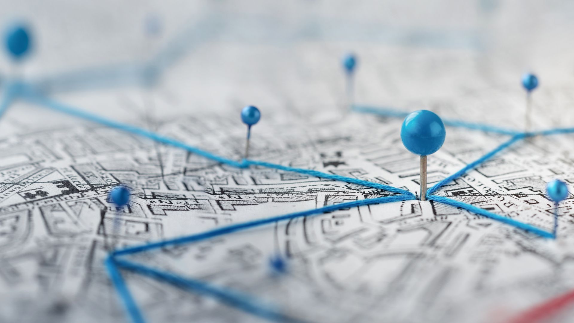 A close up of a map with blue pins on it.