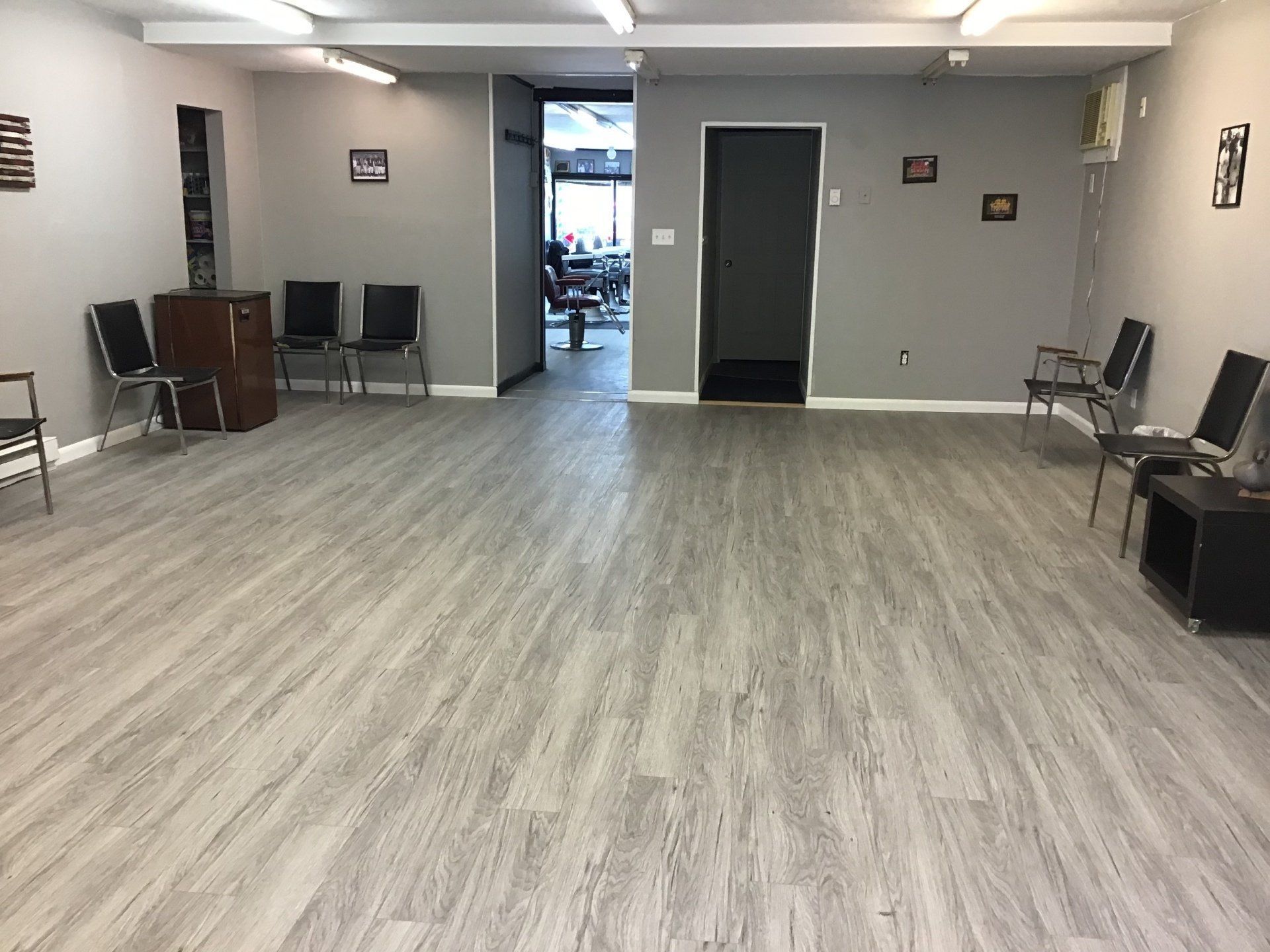 A large room with a wooden floor and chairs in it.