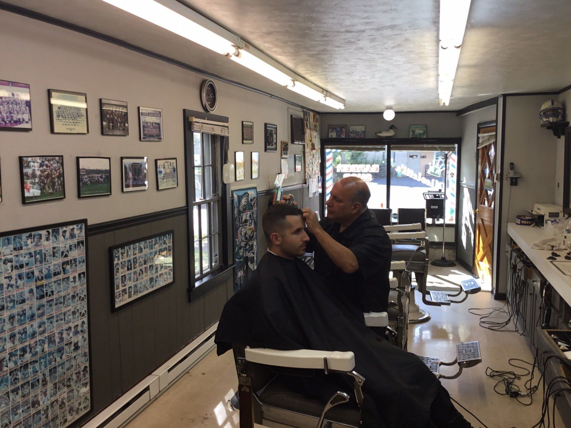 A man is getting his hair cut at a barber shop