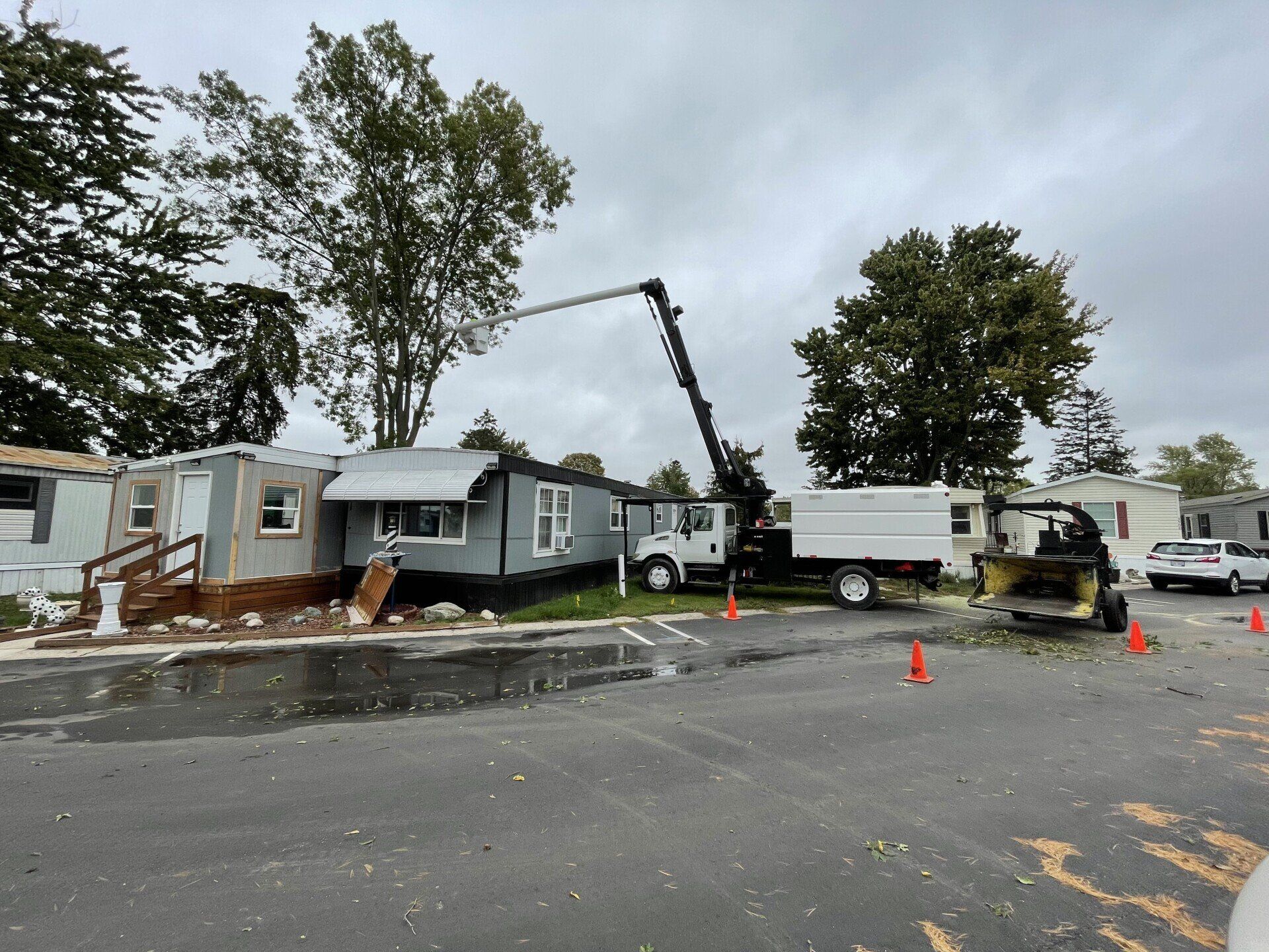 A man is holding a large piece of wood in front of a certified truck