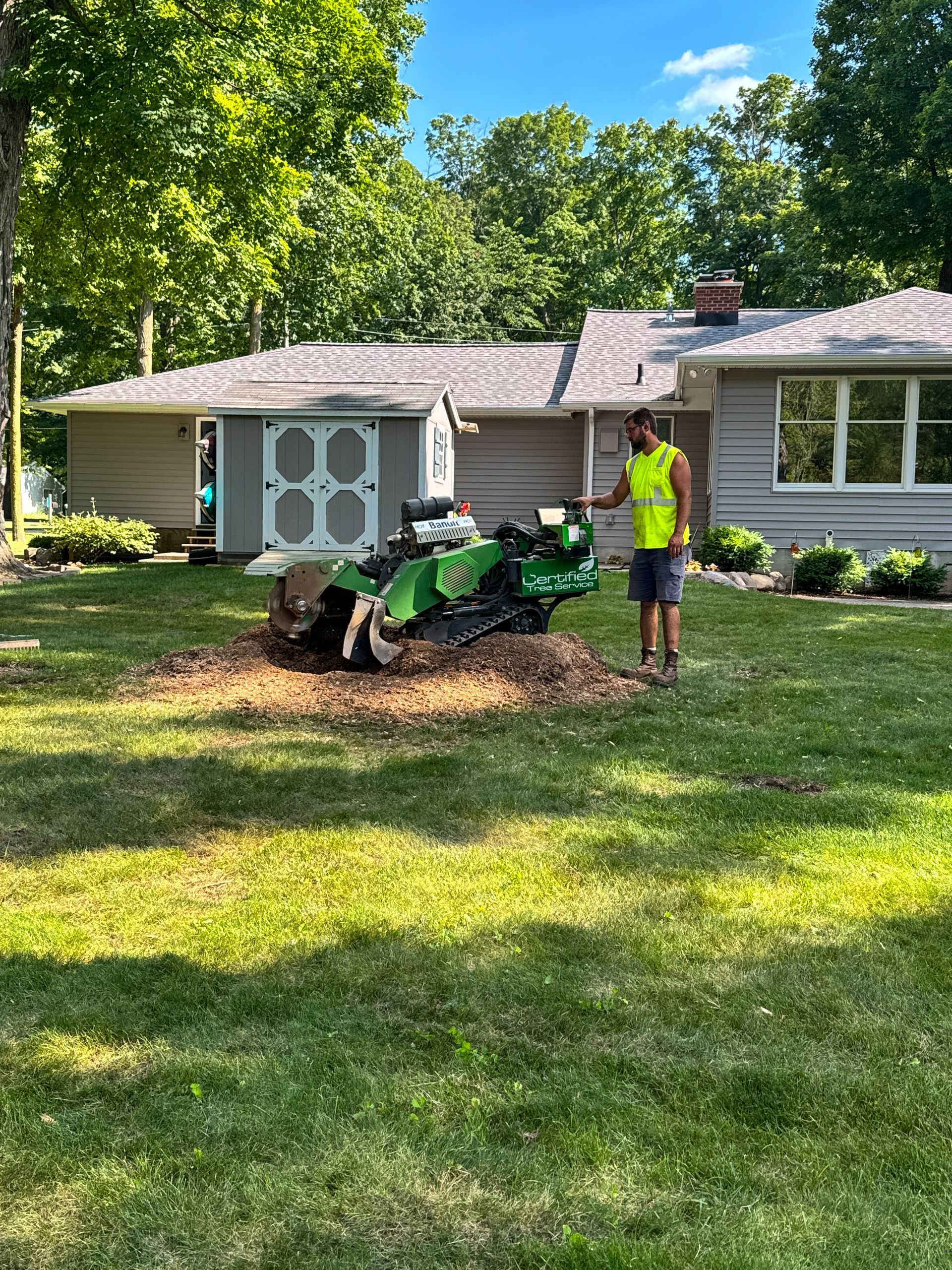A man in a yellow safety vest is standing next to a truck.