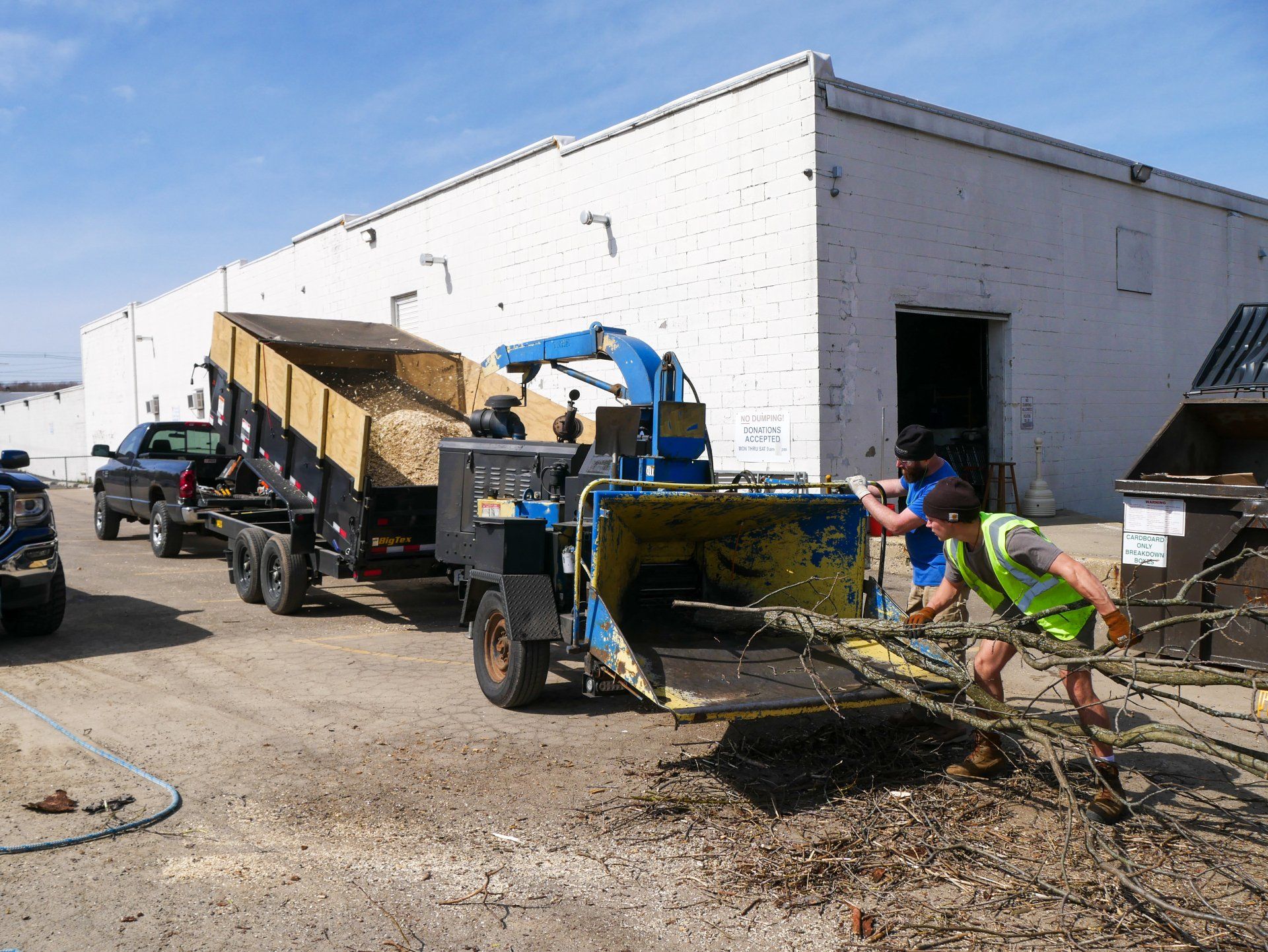 A man is pushing a machine in front of a building.
