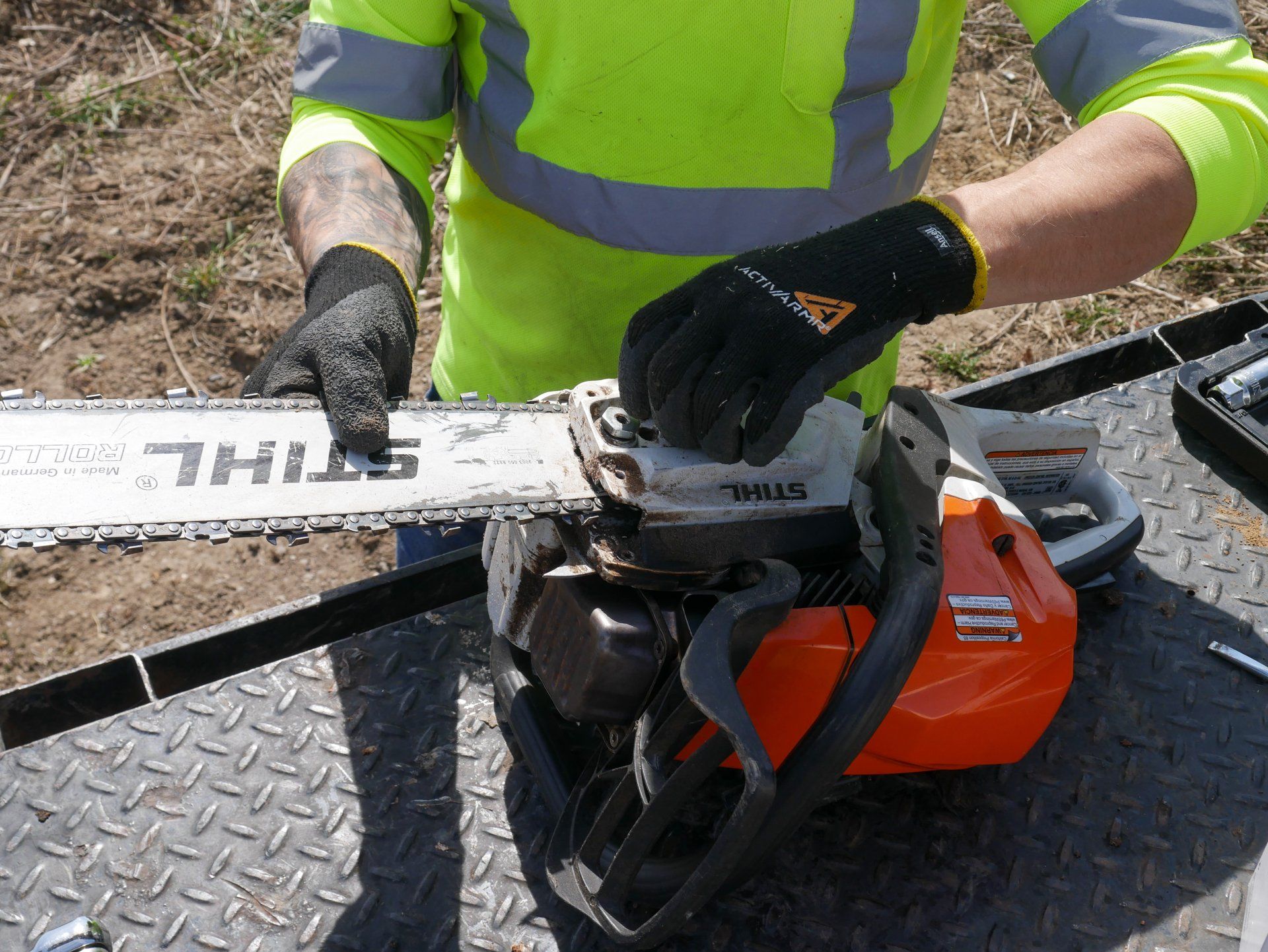 A man is working on a stihl chainsaw