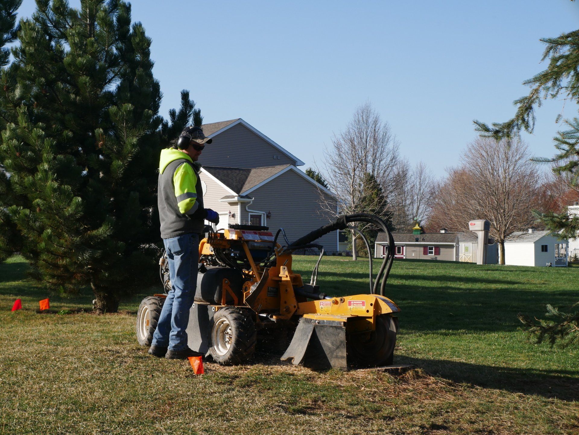 A man is using a stump grinder to remove a tree stump.