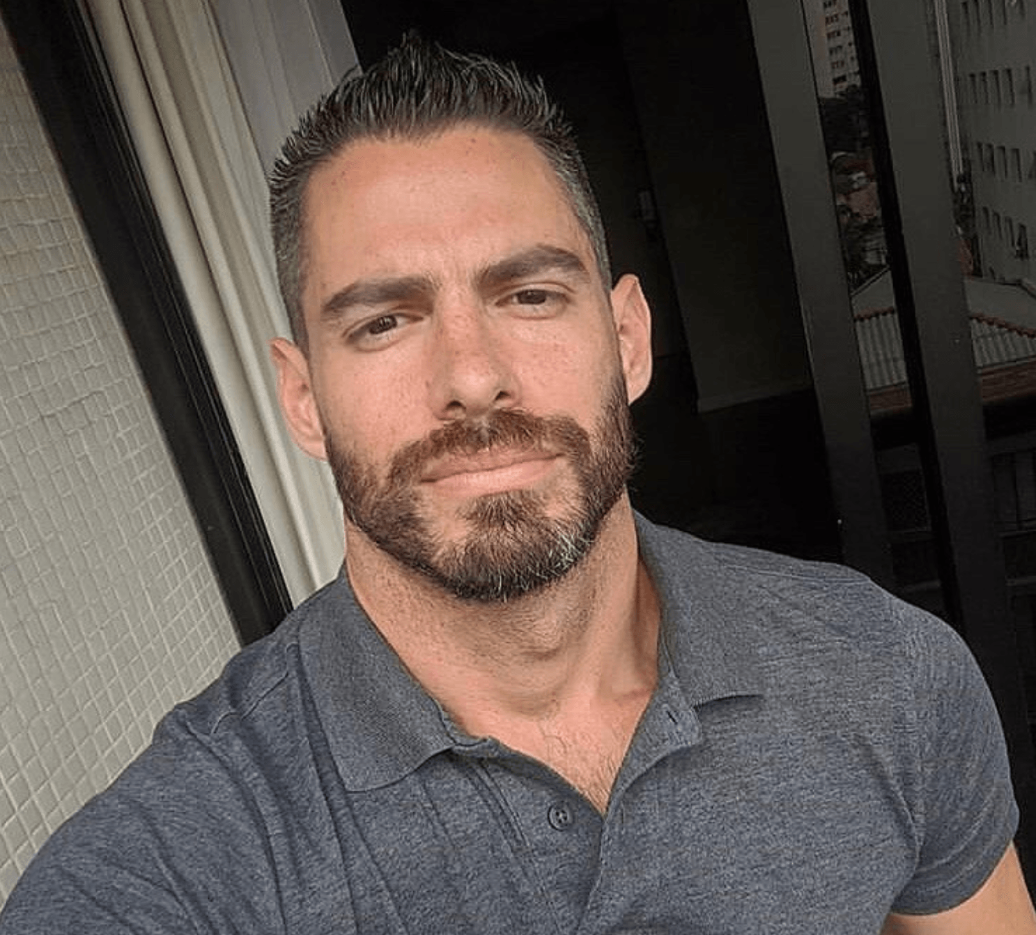 A man with a beard and mustache is taking a selfie.