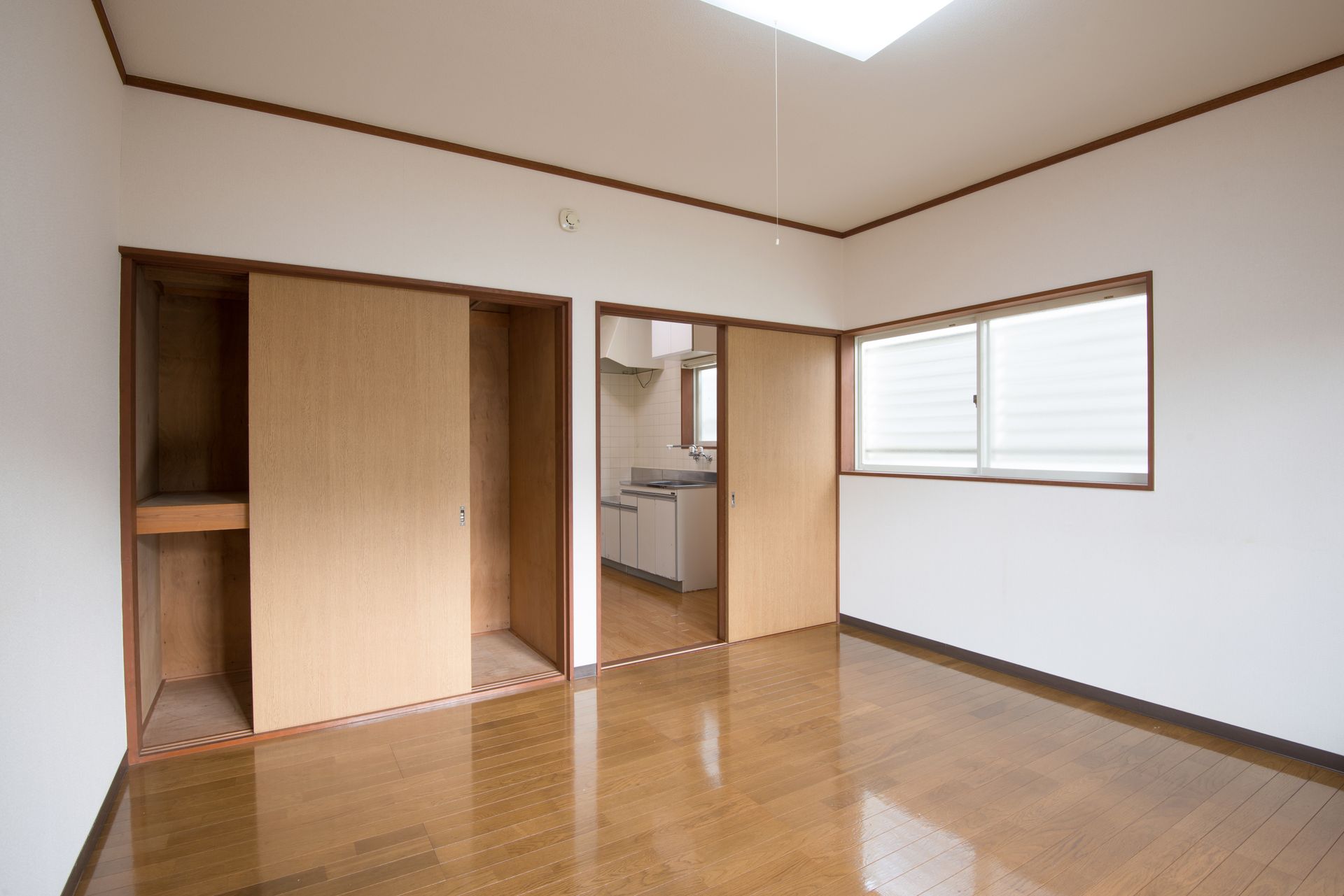 An empty room with wooden floors and white walls