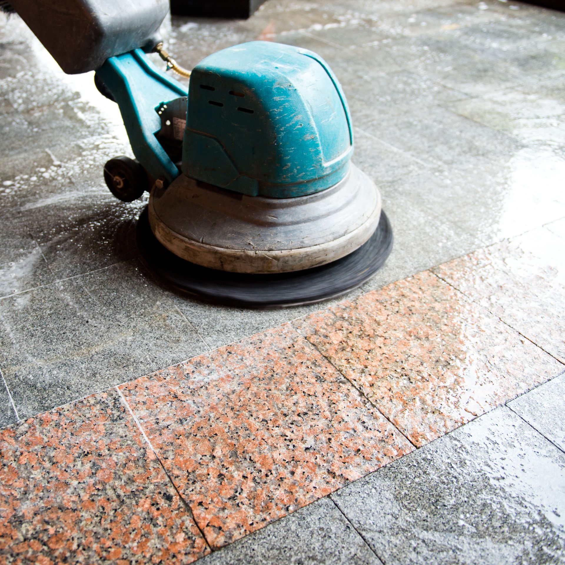 A person is cleaning a white tile wall with a sponge.
