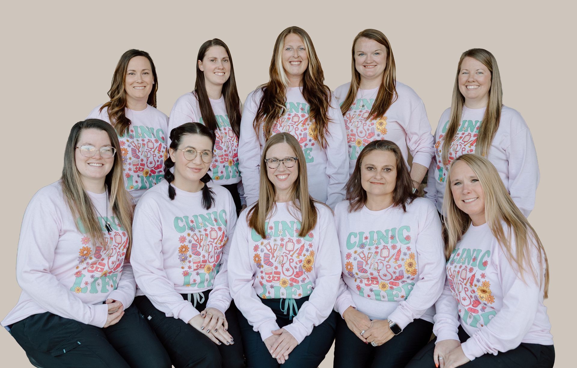 Group of healthcare workers in matching pink shirts, posing. photo of cabot health & wellness team.