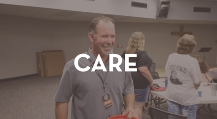 A man holding a red bucket with the word care on it