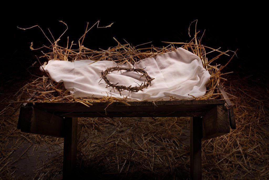 A wooden manger with a crown of thorns on top of it.