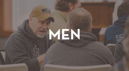 A group of men are sitting at a table and the word men is above them