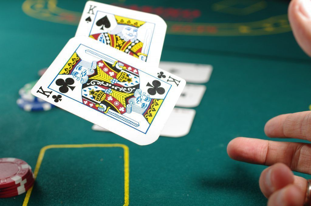 A king spades card is being thrown in the air