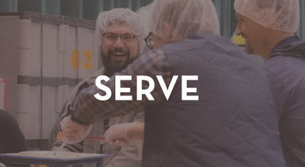 A group of people are standing around a table with the word serve on the bottom.