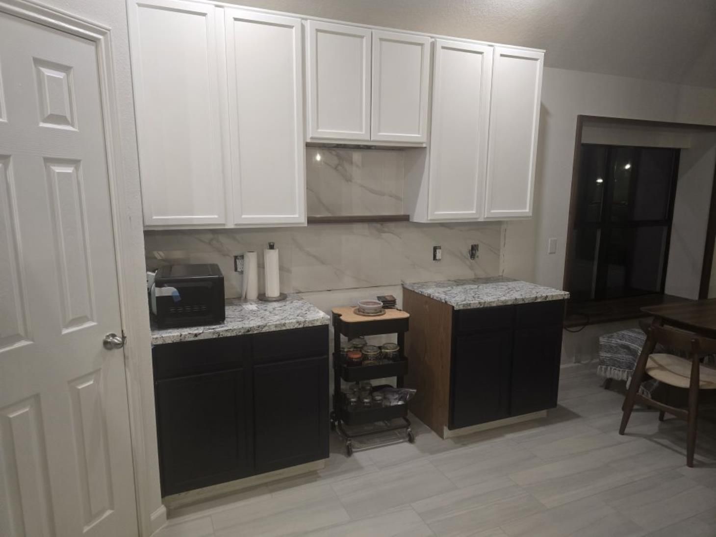 A person using a handheld vacuum cleaner to clean a mattress surface.