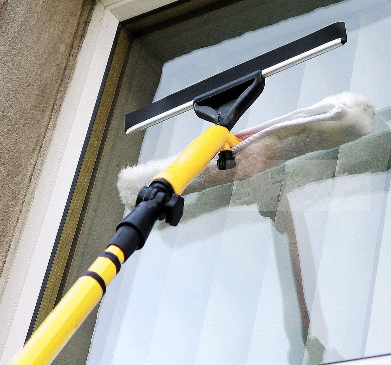 A person using a handheld vacuum cleaner to clean a mattress surface.